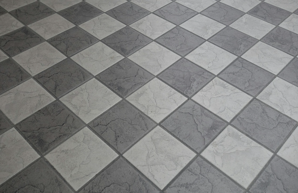 Diagonal view of ceramic tiles featuring a checkerboard pattern of dark gray and light gray textured square tiles
