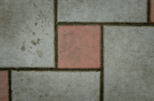 Close-up view of outdoor tiles with red and gray squares, featuring visible grout lines between the tiles