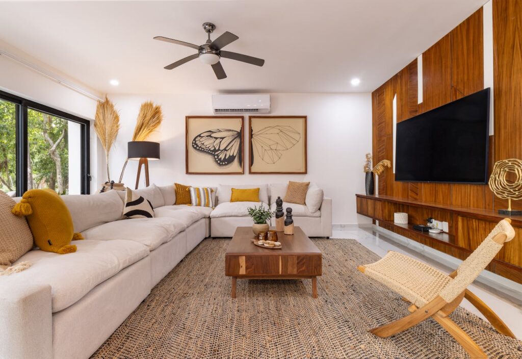 Modern living room with a large sectional sofa, wooden coffee table, and wall-mounted TV, featuring flooring supported by quality flooring underlayment for durability and comfort.